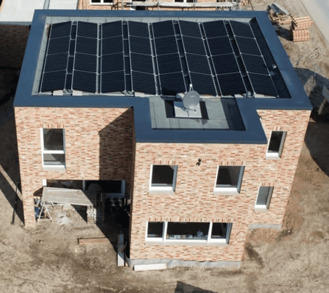 Dachaufsicht eines modernen Hauses mit schwarzen Solarmodulen.