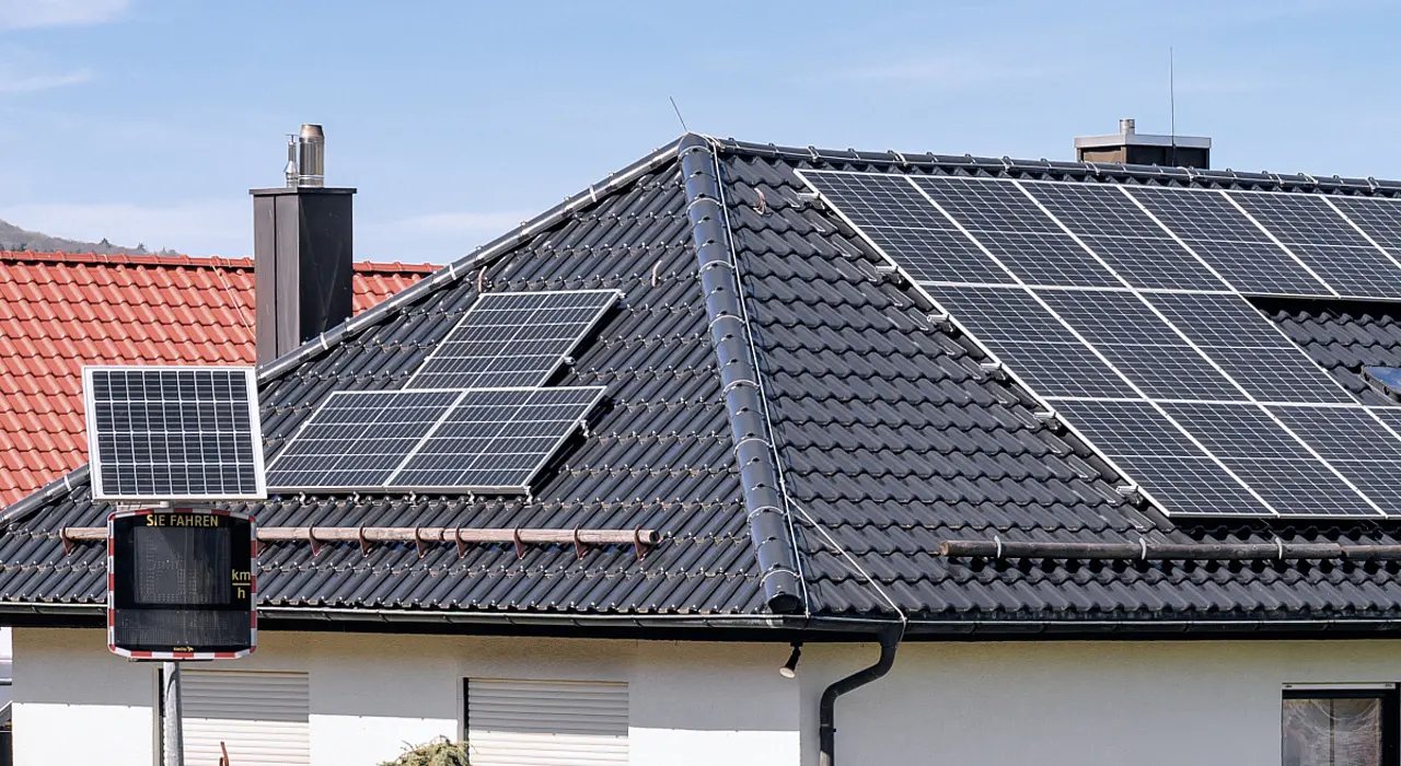 Dunkles Ziegeldach mit mehreren Photovoltaikmodulen.